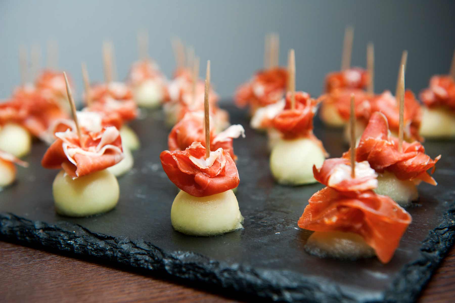 Pinchos de jamon con melon sobre tabla de pizarra